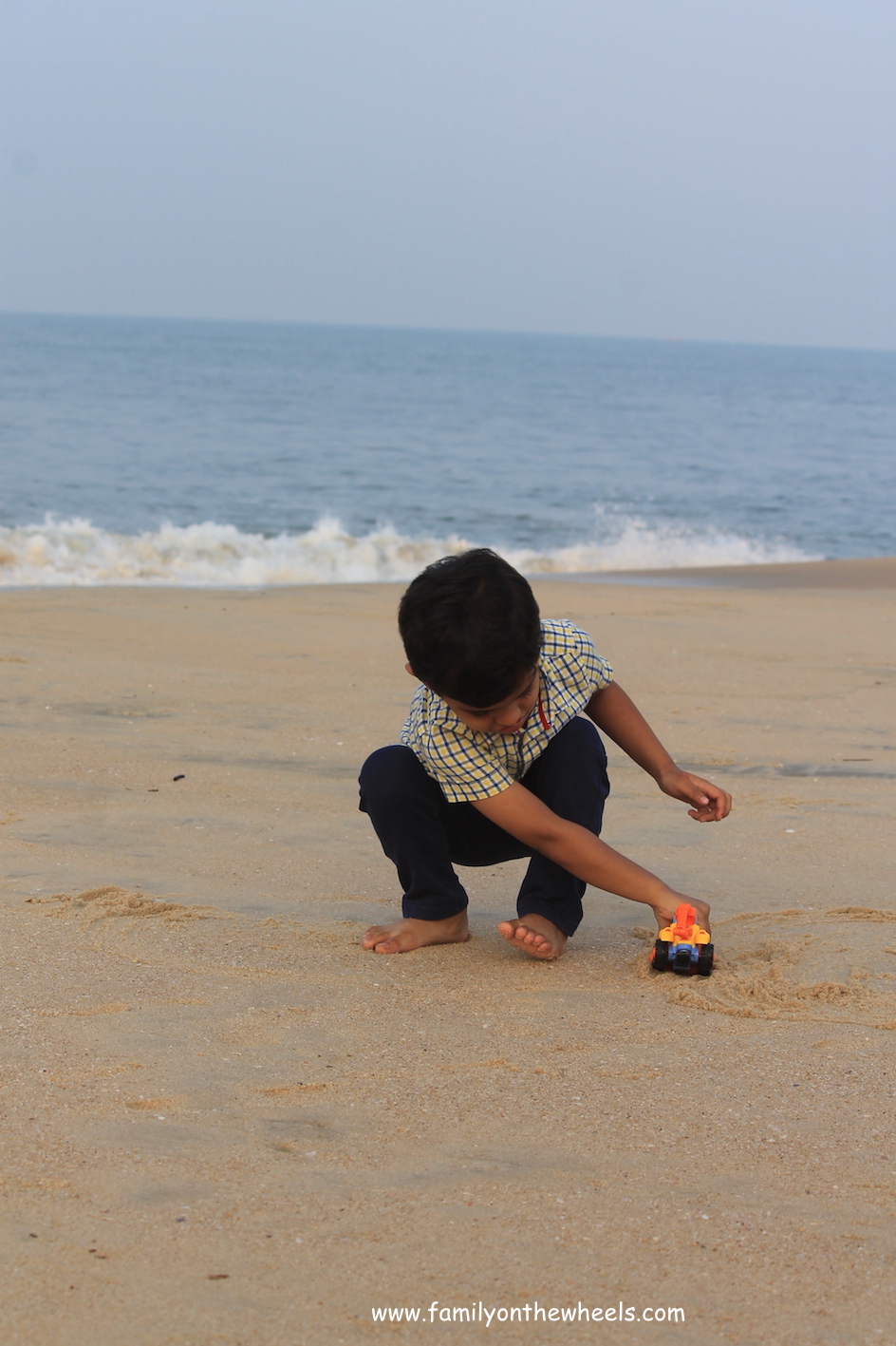 kid driving car on beach 